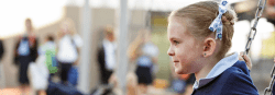 A girl swings in the playground while ignoring everyone around