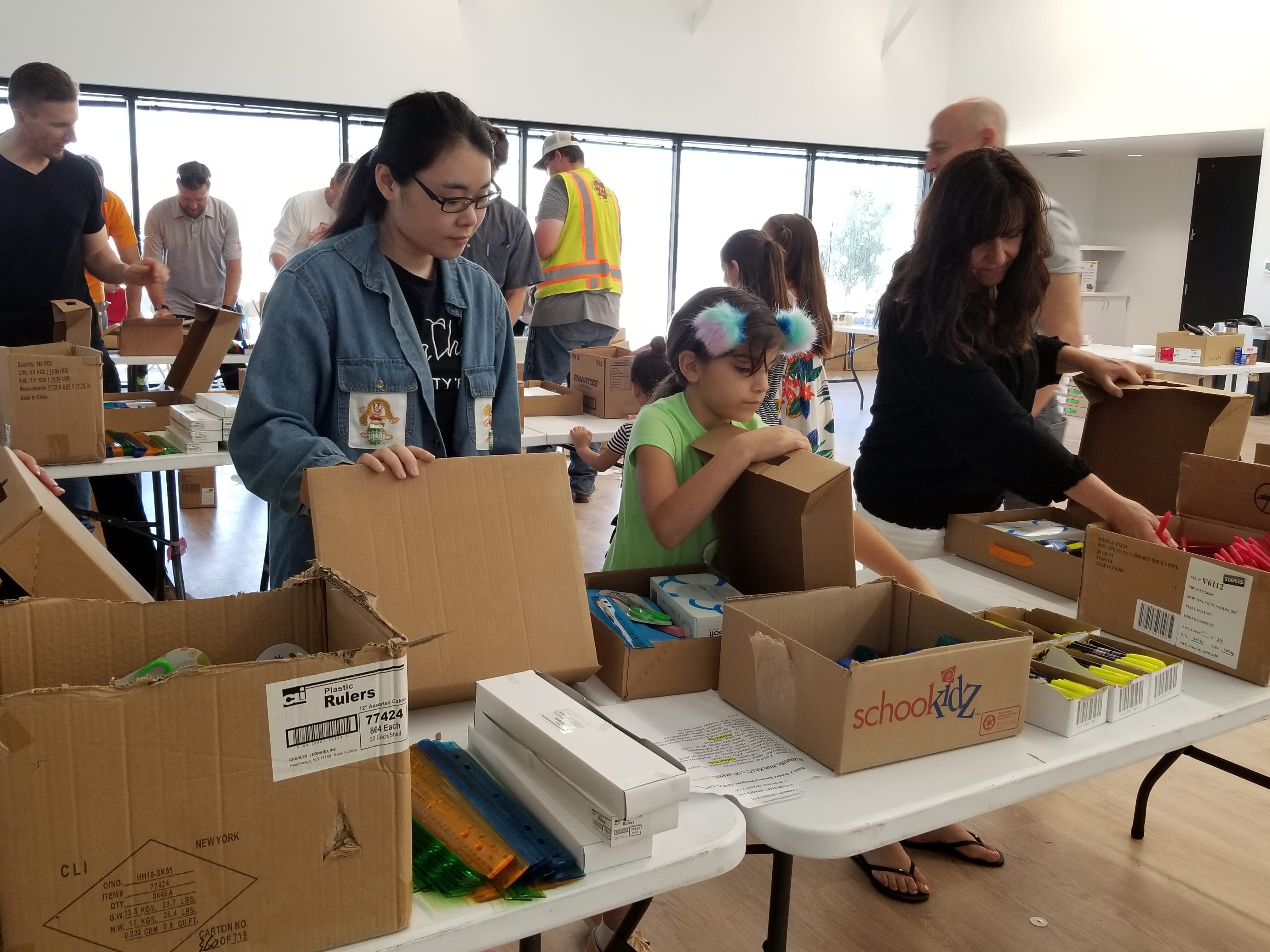 Volunteers fill boxes with school supplies
