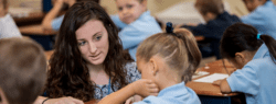 female teacher helping a student at her desk