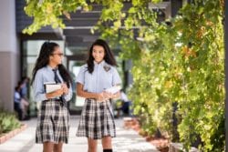 high school girls walking with books in hand