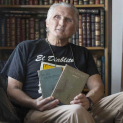 man holding Latin books