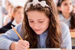 female student writing at desk