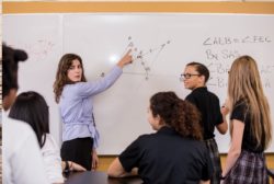 female teacher with math problem on white board