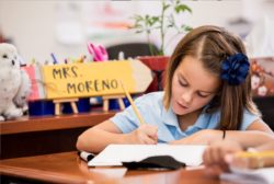 young girl writing at desk