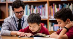 male teacher with young boy reading