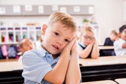 little boy with hands on head