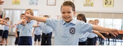 boy standing with arms out in gym class