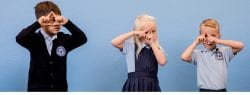 3 kids standing in front of blue wall