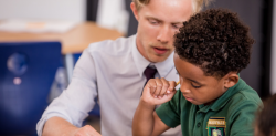 teacher with boy at desk