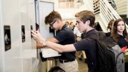 2 students at a row of lockers in a busy hall