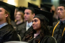 Close up of a graduate with additional graduates in the background