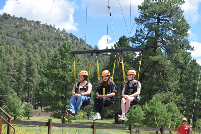 3 students on a suspension swing