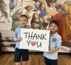 2 students holding a Thank You sign