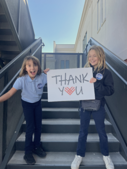 2 students holding a Thank You sign