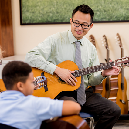 Music teacher teaching guitar