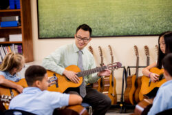Music teacher teaching guitar