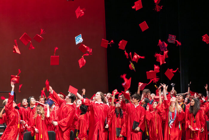 Graduates throwing their caps up in the air