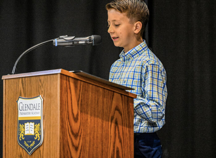 Student giving speech on a virtue at 5th grade promotion ceremony