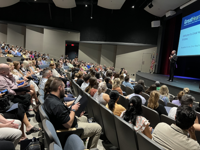 Auditorium filled with attendees at Great Hearts New Faculty Orientation (NFO) with a speaker up front.