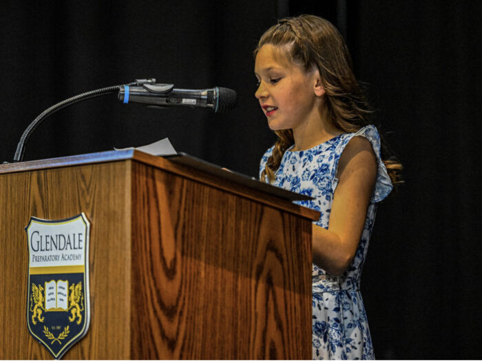 Student giving speech on a virtue at 5th grade promotion ceremony