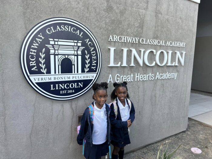 students posing in front of the Archway Lincoln signage