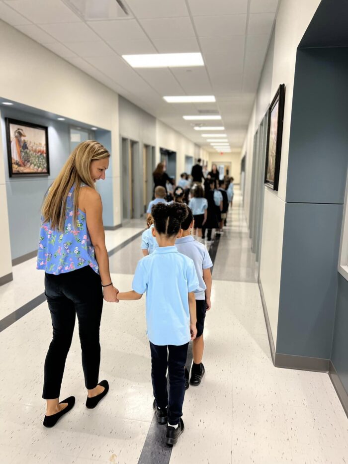 Teacher walking with student on first day of school at GH Harveston