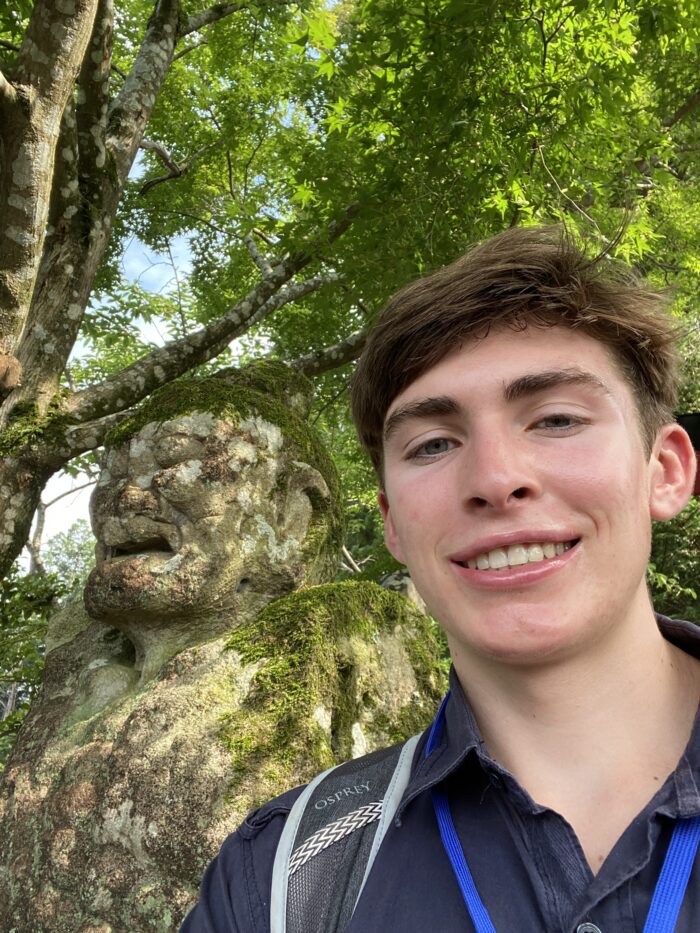 Student posing with a centuries-old statue