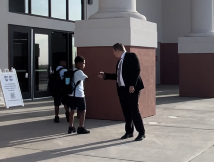 Headmaster Philabaum greeting a student at GH Roosevelt