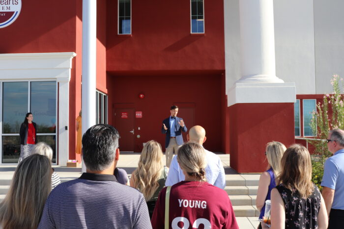 Headmaster Zack Withers addressing parents in front of school.