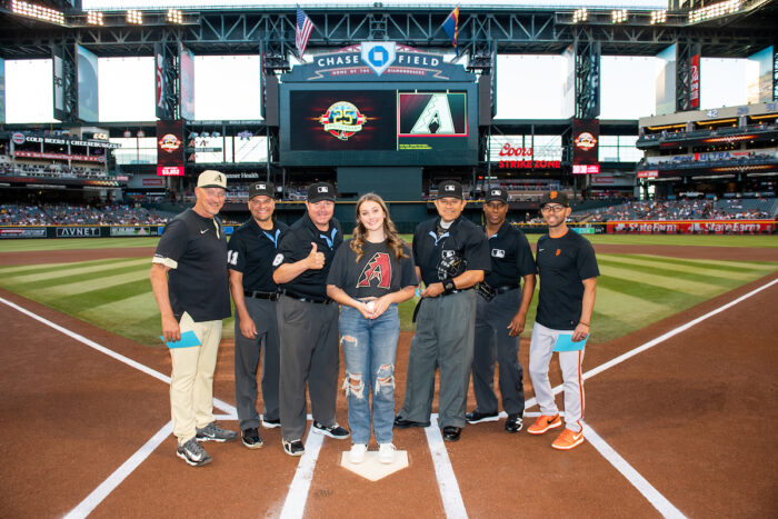 Honorary D-backs team captain with umpires at home plate at Great Hearts Day