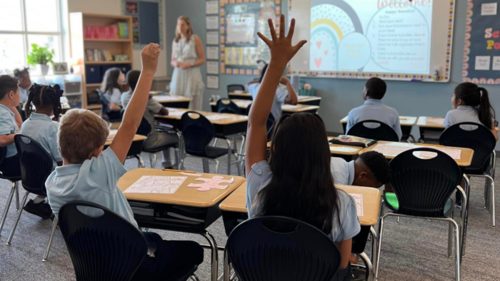Students raising hands in a classroom