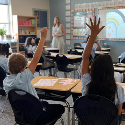 Students raising hands in a classroom