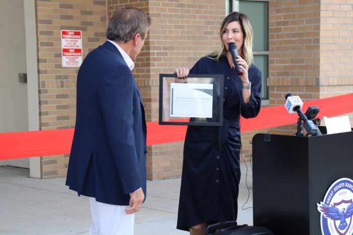 Genevieve Peterson presenting plaque to Mike Wompold