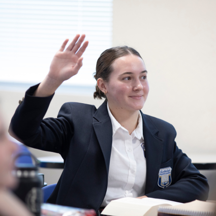 Scholar raising her hand in class.