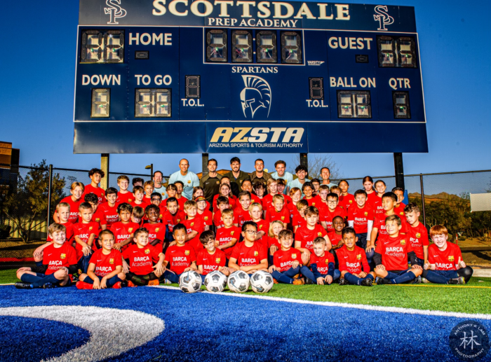 2023 Barca Soccer Camp group photo in front of scoreboard