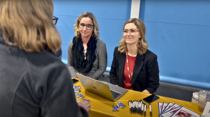School leaders speaking with candidate at hiring event