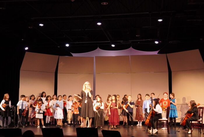 Mrs. Carpenter with her music students on stage