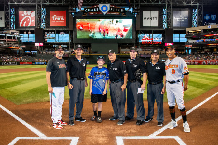 Great Hearts student with umpires at Great Hearts Day at Chase Field