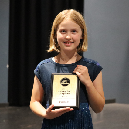 The 2024 Great Hearts Bard, Elinor P., with her plaque