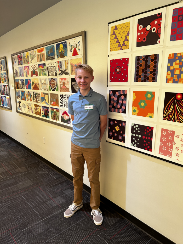 Student in front of artwork at Veritas Art Walk