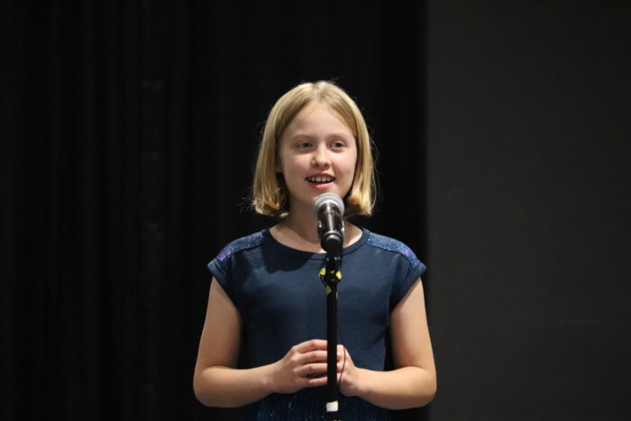 The 2024 Great Hearts Bard, Elinor P., with a microphone