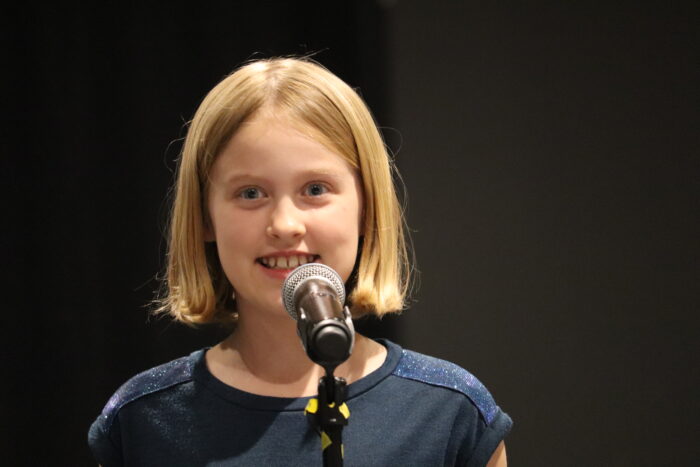 The 2024 Great Hearts Bard, Elinor P., with a microphone