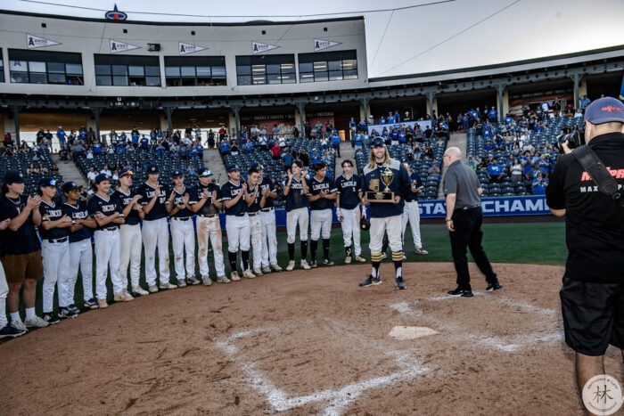 Paul Schubring posing behind home plate with the Lincoln Prep baseball team