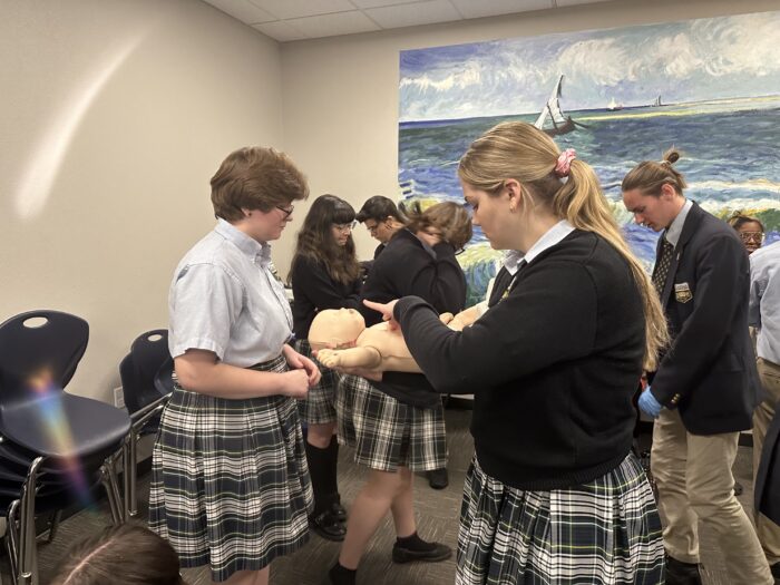 Student performing CPR simulation on an infant mannequin