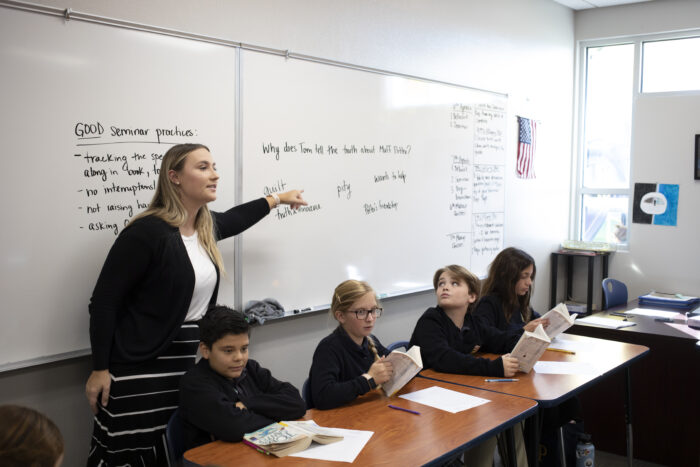 A teacher at a whiteboard with students