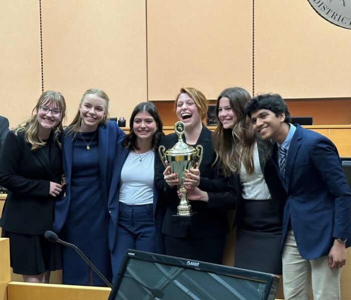 Veritas Prep Mock Trial candid team photo with trophy