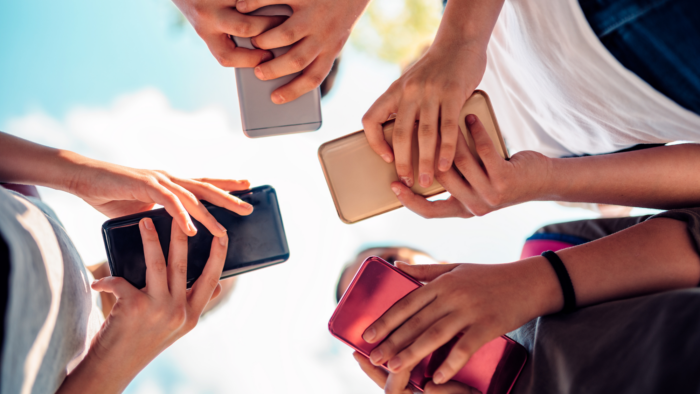 view from below of kids with cell phones