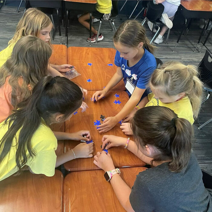 Summer camp scholars working on a puzzle