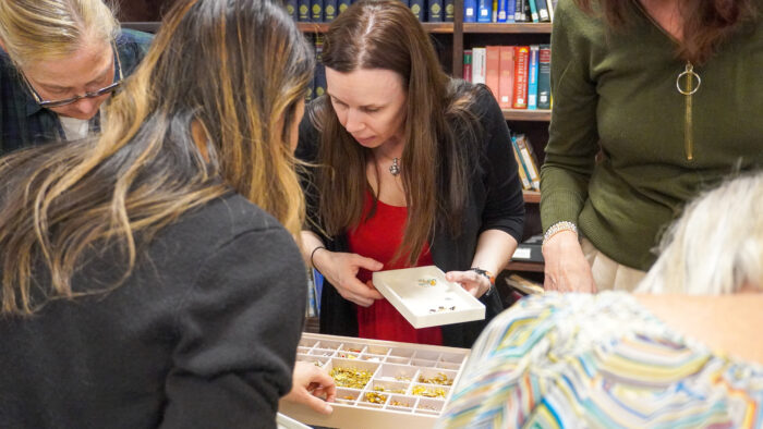 A group of office managers looking through boxes of charms