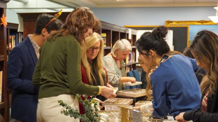 A group of office managers looking through boxes of charms